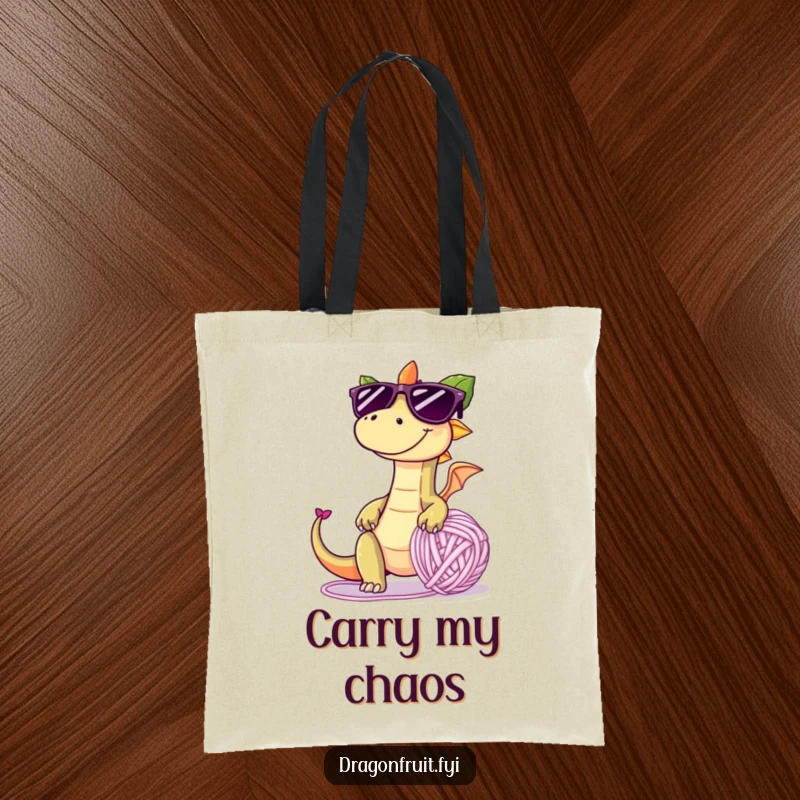 Funny tote bag showing a dragonfruit in oversized sunglasses, tripping over a giant yarn ball, perfect for carrying items with a smile.